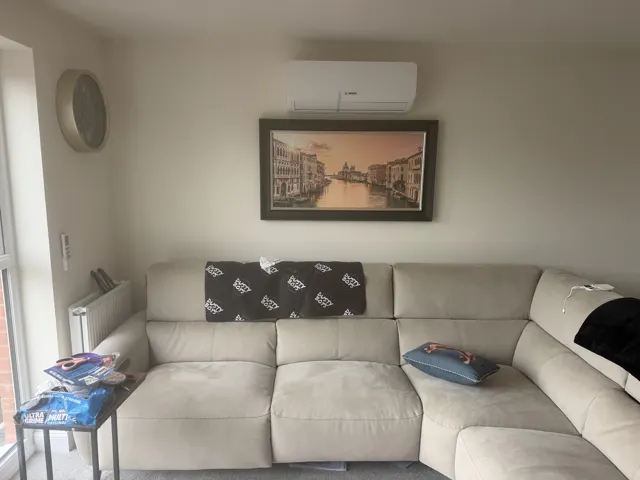 Bosch indoor air-conditioning unit on a living-room wall above a sofa.