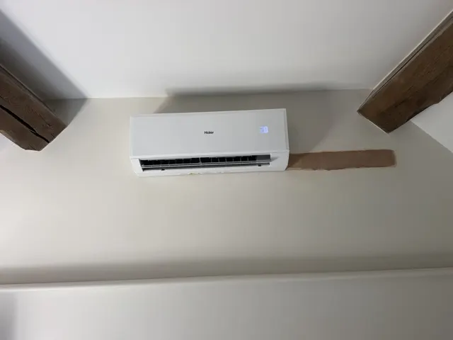 Haier indoor air-conditioning unit mounted high on a wall.