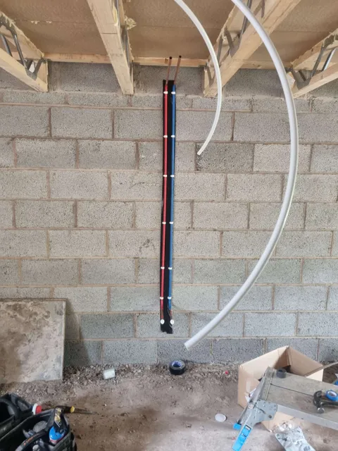 Pipework within a blockwork wall during first-fix work.